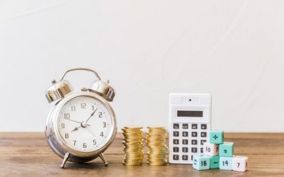 alarm-clock-stacked-coins-calculator-math-blocks-wooden-desk_23-2147863934