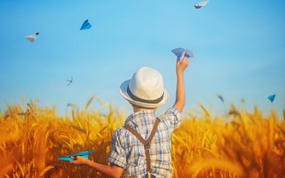 cute-child-holding-hand-paper-airplane-wheat-golden-field-sunny-summer-day_90791-22